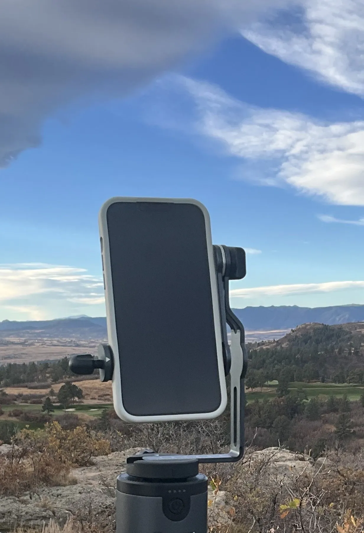 A cell phone is mounted on the side of a pole.