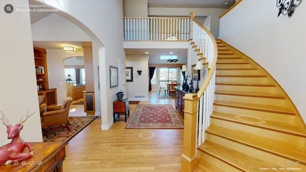 A large open living room with stairs leading to the second floor.