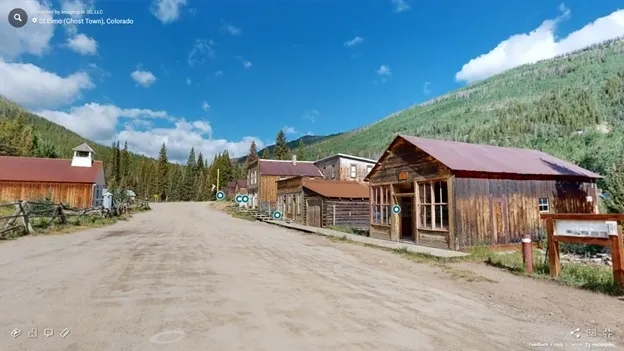 A dirt road with buildings on the side of it.