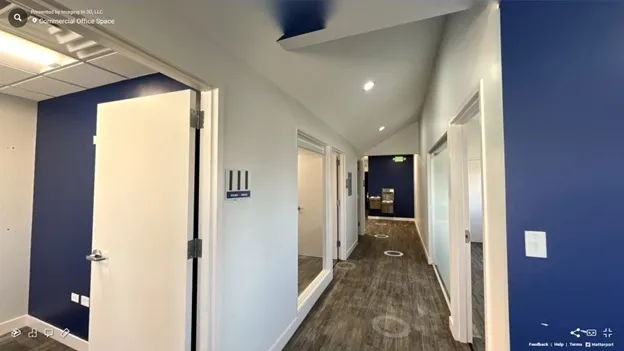 A hallway with mirrors and doors leading to the bathroom.