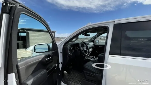 A truck with the door open and steering wheel in view.